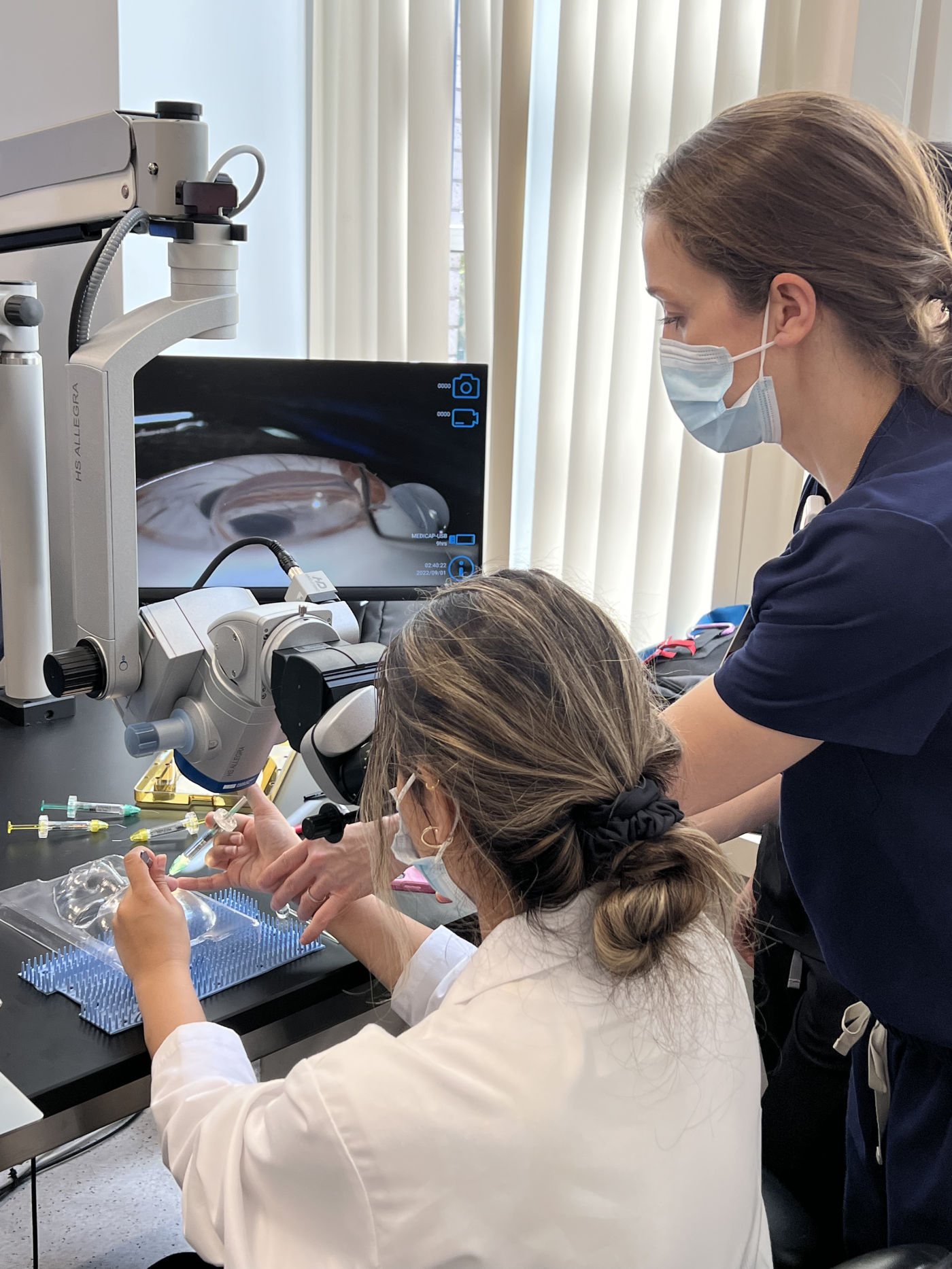 Resident looking through magnifier practicing microsurgical procedure